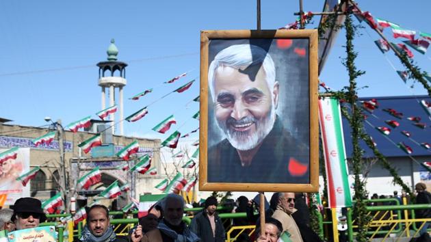 An Iranian man holds a picture of the late Iran's Quds Force top commander Qassem Soleimani, during the commemoration of the 41st anniversary of the Islamic revolution in Tehran, Iran.(REUTERS)