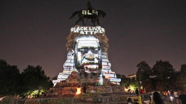 An image of George Floyd is projected on the base of the statue of Confederate General Robert E. Lee on Monument Avenue, Monday, June 8, 2020, in Richmond, Va. The statue has been the focal point of protester over the death of George Floyd. Virginia Gov. Ralph Northam has ordered the removal of the statue.(AP) An image of George Floyd is projected on the base of the statue of Confederate General Robert E. Lee on Monument Avenue, Monday, June 8, 2020, in Richmond, Va. The statue has been the focal point of protester over the death of George Floyd. Virginia Gov. Ralph Northam has ordered the removal of the statue.(AP)