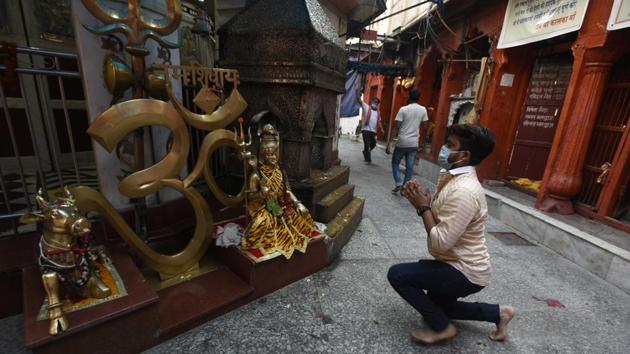 A devotee prays at the Kalkaji temple in New Delhi after it reopened on June 8 as part of measures constituting the first major step of an exit from lockdown. The face mask is now deemed battle worthy armour in reducing the risk of coronavirus transmission. (Biplov Bhuyan / HT Photo)