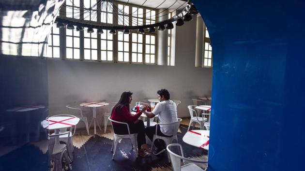 Visitors inside Cha Bar in New Delhi after the restaurant reopened to public on June 8. Mandatory social distancing in public setting adds to an appreciation of personal spaces but comes coupled with a detachment from those delivering the experience to us, now anonymised by masks, shields and even bodysuits. (Sanchit Khanna / HT PHOTO)