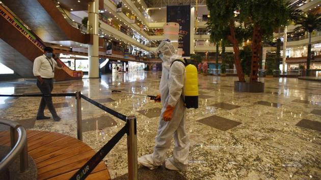 There is little alarm anymore at the sight of sanitation workers head to toe in PPE coveralls or with tanks strapped to their backs as they diligently go about disinfecting spaces for public use like here at Gaur City Mall in Greater Noida on June 9. (Virendra Singh Gosain / HT Photo)