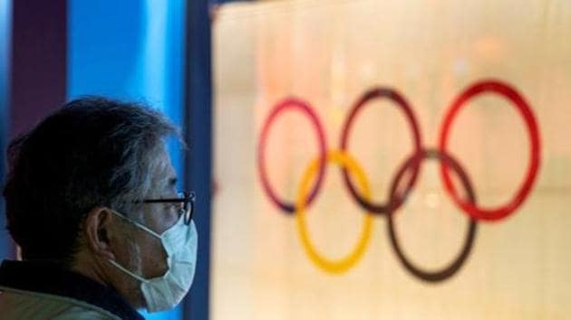 FILE PHOTO: A man wearing a protective face mask, following an outbreak of the coronavirus, stands in front of The Tokyo Olympic flag 1964 at The Japan Olympics museum in Tokyo, Japan, February 26, 2020. REUTERS/Athit Perawongmetha(REUTERS) FILE PHOTO: A man wearing a protective face mask, following an outbreak of the coronavirus, stands in front of The Tokyo Olympic flag 1964 at The Japan Olympics museum in Tokyo, Japan, February 26, 2020. REUTERS/Athit Perawongmetha(REUTERS)