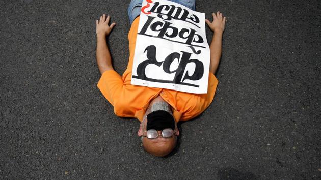 A protester with a placard that reads “What is the tax for?” lies on the road during a demonstration near the Prime Minister’s official residence, demanding better and effective response from the government to fight the coronavirus as the number of infections spikes, in Kathmandu, Nepal on June 9. (Navesh Chitrakar / REUTERS) A protester with a placard that reads “What is the tax for?” lies on the road during a demonstration near the Prime Minister’s official residence, demanding better and effective response from the government to fight the coronavirus as the number of infections spikes, in Kathmandu, Nepal on June 9. (Navesh Chitrakar / REUTERS)