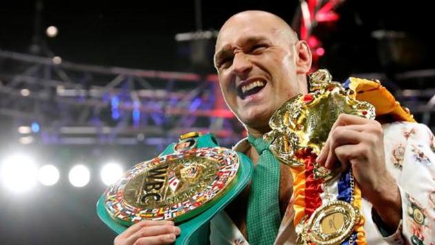 Tyson Fury poses with his belts during a press conference after the fight.(REUTERS)