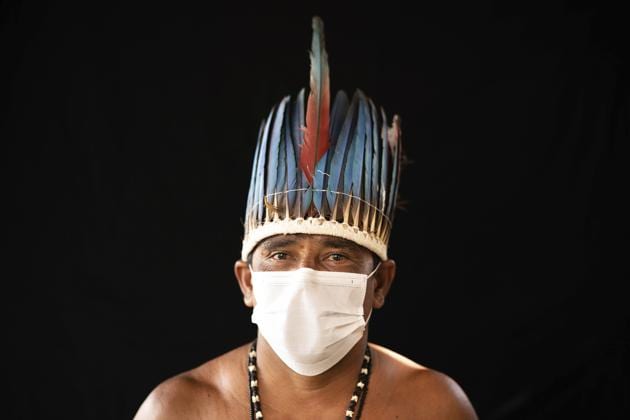 Eleomar da Silva, 44, of the Sateré Mawé indigenous ethnic group, poses for a portrait wearing the traditional dress of his tribe and a face mask amid the spread of the new coronavirus in the Gaviao community near Manaus, Brazil, Friday, May 29, 2020. (AP Photo/Felipe Dana) (AP) Eleomar da Silva, 44, of the Sateré Mawé indigenous ethnic group, poses for a portrait wearing the traditional dress of his tribe and a face mask amid the spread of the new coronavirus in the Gaviao community near Manaus, Brazil, Friday, May 29, 2020. (AP Photo/Felipe Dana) (AP)