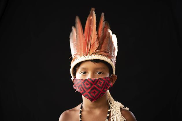 Six-year-old Elano de Souza, of the Sateré Mawé indigenous ethnic group, poses for a portrait wearing the traditional dress of his tribe and a face mask amid the spread of the new coronavirus in the Gaviao community near Manaus, Brazil, Friday, May 29, 2020. (AP Photo/Felipe Dana) (AP) Six-year-old Elano de Souza, of the Sateré Mawé indigenous ethnic group, poses for a portrait wearing the traditional dress of his tribe and a face mask amid the spread of the new coronavirus in the Gaviao community near Manaus, Brazil, Friday, May 29, 2020. (AP Photo/Felipe Dana) (AP)