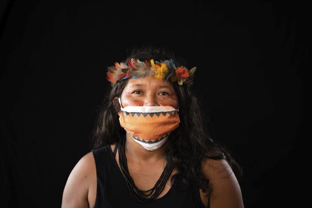Terezinha de Souza, 45, of the Sateré Mawé indigenous ethnic group, poses for a portrait wearing the traditional dress of her tribe and a face mask amid the spread of the new coronavirus in the Gaviao community near Manaus, Brazil, Friday, May 29, 2020. At the end of May, de Souza fell ill with fever, body aches, and a dry cough, and when her health deteriorated she crossed the river to the indigenous wing of the Manaus hospital, inaugurated just a few days earlier, where she has first turned away but later admitted. In de Souza's opinion, hospitalizations in her community could have been avoided had a nurse or doctor visited them at earlier stages of the pandemic. (AP Photo/Felipe Dana) (AP) Terezinha de Souza, 45, of the Sateré Mawé indigenous ethnic group, poses for a portrait wearing the traditional dress of her tribe and a face mask amid the spread of the new coronavirus in the Gaviao community near Manaus, Brazil, Friday, May 29, 2020. At the end of May, de Souza fell ill with fever, body aches, and a dry cough, and when her health deteriorated she crossed the river to the indigenous wing of the Manaus hospital, inaugurated just a few days earlier, where she has first turned away but later admitted. In de Souza's opinion, hospitalizations in her community could have been avoided had a nurse or doctor visited them at earlier stages of the pandemic. (AP Photo/Felipe Dana) (AP)