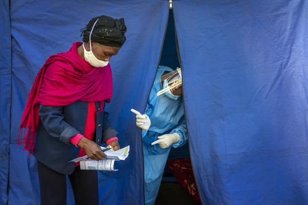 Heath officials check the listings of people who are to be tested for Covid-19 as well as HIV and Tuberculosis, in downtown Johannesburg. (AP) Heath officials check the listings of people who are to be tested for Covid-19 as well as HIV and Tuberculosis, in downtown Johannesburg. (AP)