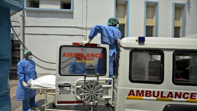 Health workers wheel the body of a man who died due to coronavirus into an ambulance at Lok Nayak Jai Prakash (LNJP) Hospital as it is taken for cremation in New Delhi on Wednesday. (Biplov Bhuyan/HT PHOTO) Health workers wheel the body of a man who died due to coronavirus into an ambulance at Lok Nayak Jai Prakash (LNJP) Hospital as it is taken for cremation in New Delhi on Wednesday. (Biplov Bhuyan/HT PHOTO)