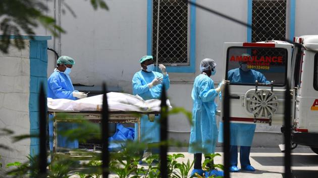 A medical team wheels out the body of a person who died of Covid-19 during a handover to family members outside the mortuary, at Lok Nayak Jai Prakash (LNJP) hospital in New Delhi on Thursday. (Raj K Raj/HT PHOTO) A medical team wheels out the body of a person who died of Covid-19 during a handover to family members outside the mortuary, at Lok Nayak Jai Prakash (LNJP) hospital in New Delhi on Thursday. (Raj K Raj/HT PHOTO)