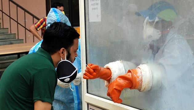 A medical worker in an enclosed booth collects swab samples for Covid-19 testing at IMS College in Dasna, Ghaziabad on Wednesday. (Sakib /HT File Photo) A medical worker in an enclosed booth collects swab samples for Covid-19 testing at IMS College in Dasna, Ghaziabad on Wednesday. (Sakib /HT File Photo)