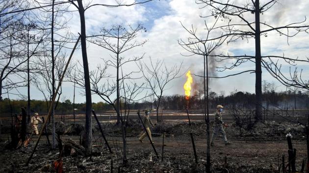 Security personnel walk near the site of the explosion at Baghjan on June 10. Farmland with standing crops, as well as ponds and wetlands in the adjoining villages have been badly affected by the initial explosion fuelled by gas condensate. The fire burnt everything in a radius of one km from the site, according to OIL officials. (Partha Sarathi Das / AP) Security personnel walk near the site of the explosion at Baghjan on June 10. Farmland with standing crops, as well as ponds and wetlands in the adjoining villages have been badly affected by the initial explosion fuelled by gas condensate. The fire burnt everything in a radius of one km from the site, according to OIL officials. (Partha Sarathi Das / AP)