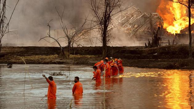 National Disaster Response Force (NDRF) personnel participate in a rescue operation at the site in Baghjan. Workers have been trying to cap the well since gas started leaking nearly two weeks ago, said Tridiv Hazarika, a spokesman for government-owned Oil India Limited, which operates the gas field in Baghjan. (Partha Sarathi das / AP) National Disaster Response Force (NDRF) personnel participate in a rescue operation at the site in Baghjan. Workers have been trying to cap the well since gas started leaking nearly two weeks ago, said Tridiv Hazarika, a spokesman for government-owned Oil India Limited, which operates the gas field in Baghjan. (Partha Sarathi das / AP)