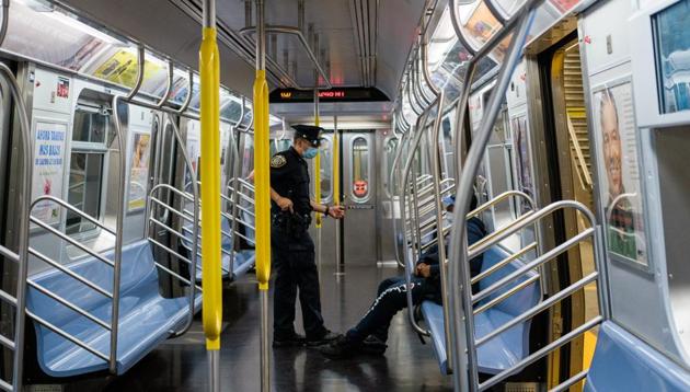 A New York City Police (NYPD) officer wearing a protective mask asks a rider to exit the train so it can be disinfected at the 2nd Ave-96th Street subway station in New York, US on Wednesday(Bloomberg File Photo) A New York City Police (NYPD) officer wearing a protective mask asks a rider to exit the train so it can be disinfected at the 2nd Ave-96th Street subway station in New York, US on Wednesday(Bloomberg File Photo)