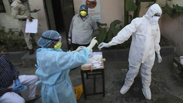 A health worker transfers sample of a person from a swab test for Covid-19 in New Delhi.(AP)