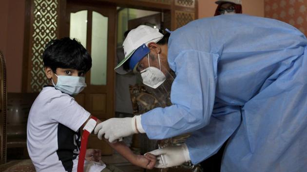 A health worker takes blood sample of a boy during door-to-door testing and screening facility for the coronavirus disease, in Islamabad on Wednesday. (AP Photo) A health worker takes blood sample of a boy during door-to-door testing and screening facility for the coronavirus disease, in Islamabad on Wednesday. (AP Photo)