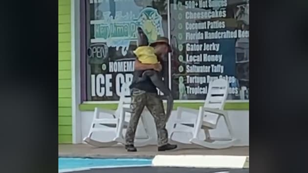 The image shows the man carrying the alligator named Sweetie.(TikTok/rachel_bowman)