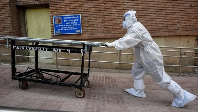 A Medical professional wearing PPE coveralls pushes a stretcher outside the Covid-19 ward at LNJP Hospital in New Delhi on Tuesday.(Biplov Bhuyan/HT PHOTO) A Medical professional wearing PPE coveralls pushes a stretcher outside the Covid-19 ward at LNJP Hospital in New Delhi on Tuesday.(Biplov Bhuyan/HT PHOTO)