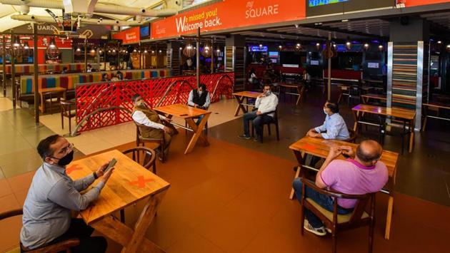 People wait for their meals while maintaining social distance inside the food court at Select Citywalk mall in Saket. Government officials said it is now crucial to learn to live with the virus, a process that will involve new etiquettes such as always wearing a mask when away from home and keeping a distance of 2 metre from others. (Amal KS / HT Photo) People wait for their meals while maintaining social distance inside the food court at Select Citywalk mall in Saket. Government officials said it is now crucial to learn to live with the virus, a process that will involve new etiquettes such as always wearing a mask when away from home and keeping a distance of 2 metre from others. (Amal KS / HT Photo)