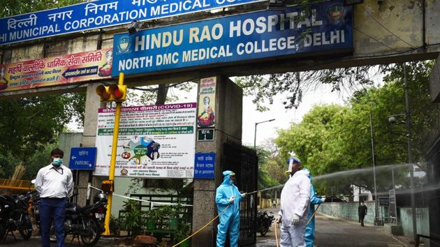 New Delhi Municipal Council (NDMC) workers spray disinfectant during the sanitization of the Hindu Rao Hospital in New Delhi.(Vipin Kumar/HT PHOTO)
