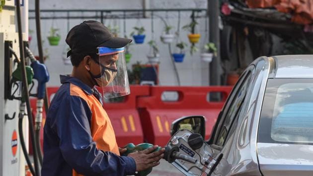 A petrol pump employee wearing a face shield while attending to a customer in Wazirpur, New Delhi.(Sanchit Khanna/HT PHOTO)