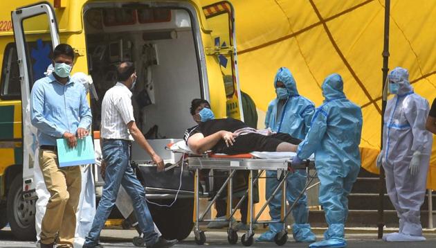 Medical professionals wearing PPE coveralls attend a patient suspected of coronavirus infection outside the Covid-19 ward, at Ganga Ram Hospital in New Delhi on Thursday. (Sanchit Khanna/HT PHOTO) Medical professionals wearing PPE coveralls attend a patient suspected of coronavirus infection outside the Covid-19 ward, at Ganga Ram Hospital in New Delhi on Thursday. (Sanchit Khanna/HT PHOTO)