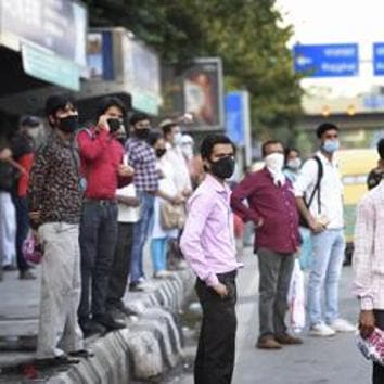 Commuters wear face masks as they wait to board a bus. (representational image)(HT PHOTO)