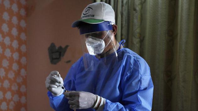 A health worker preserves a blood sample of a boy during door-to-door testing and screening facility for the coronavirus (AP) A health worker preserves a blood sample of a boy during door-to-door testing and screening facility for the coronavirus (AP)