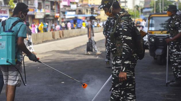 A worker sanitize on CRPF as he keeps a watch in Dharavi , a containment area in Mumbai during a government-imposed nationwide lockdown as a preventive measure against the spread of the Covid-19. (Satish Bate/HT Photo) A worker sanitize on CRPF as he keeps a watch in Dharavi , a containment area in Mumbai during a government-imposed nationwide lockdown as a preventive measure against the spread of the Covid-19. (Satish Bate/HT Photo)