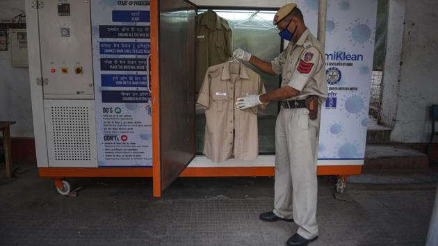 A police personnel collects his uniform from a disinfection chamber designed by Defence Research and Development Organization (DRDO) at Parliament Street Police station, New Delhi. The country reported 11,172 new cases and 384 new deaths on June 12, taking the total number of cases to 309,324, and deaths to 8,884. (Sanchit Khanna / HT Photo) A police personnel collects his uniform from a disinfection chamber designed by Defence Research and Development Organization (DRDO) at Parliament Street Police station, New Delhi. The country reported 11,172 new cases and 384 new deaths on June 12, taking the total number of cases to 309,324, and deaths to 8,884. (Sanchit Khanna / HT Photo)