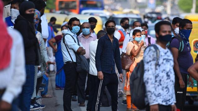 Commuters wait for public transport at ITO while flouting social distancing norms in New Delhi on Friday.(Raj K Raj/HT PHOTO)