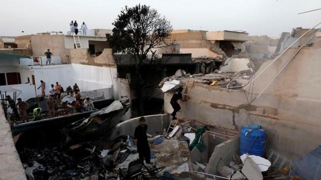 People stand on a roof of a house amidst debris of a passenger plane, crashed in a residential area near an airport in Karachi, Pakistan May 22, 2020. REUTERS/Akhtar Soomro (REUTERS) People stand on a roof of a house amidst debris of a passenger plane, crashed in a residential area near an airport in Karachi, Pakistan May 22, 2020. REUTERS/Akhtar Soomro (REUTERS)