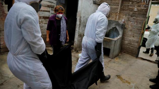 Workers of the Piedrangel crematorium pick up the body of a victim of the coronavirus disease (COVID-19) who died at home as a family member looks on, in Lima, Peru.(REUTERS/For Representative Purposes Only) Workers of the Piedrangel crematorium pick up the body of a victim of the coronavirus disease (COVID-19) who died at home as a family member looks on, in Lima, Peru.(REUTERS/For Representative Purposes Only)