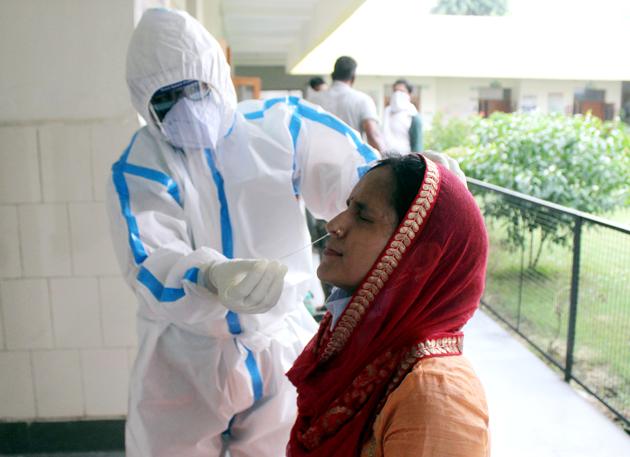 A doctor in PPE suit collects swab sample at Primary Health Centre (PHC) in Wazirabad,  Gurugram, on Saturday. (ANI Photo)