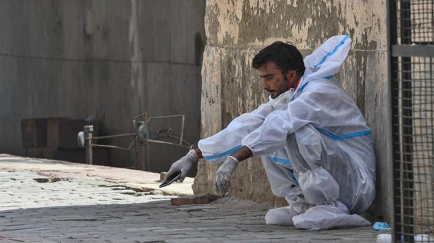 A medical professional wearing PPE coveralls rests by a wall outside the Covid-19 ward at Lok Nayak Jai Prakash (LNJP) Hospital on June 11. The Centre has promised to provide the Delhi government with necessary medical equipment. Fresh guidelines on the last rites for Covid-19 victims with an aim to reduce the waiting time for cremations are also expected. (Biplov Bhuyan / HT Photo) A medical professional wearing PPE coveralls rests by a wall outside the Covid-19 ward at Lok Nayak Jai Prakash (LNJP) Hospital on June 11. The Centre has promised to provide the Delhi government with necessary medical equipment. Fresh guidelines on the last rites for Covid-19 victims with an aim to reduce the waiting time for cremations are also expected. (Biplov Bhuyan / HT Photo)