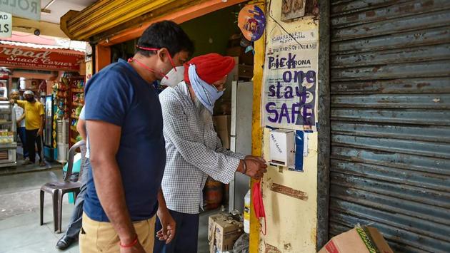 A man helps himself to a mask made by Laxmi Das from a dispenser placed in a market in CR Park on June 13. Shankar Mondal, who runs a departmental store in the area, told PTI that whenever a customer comes to his shop without wearing a mask, he advises him to take one from the box. (Arun Sharma / PTI) A man helps himself to a mask made by Laxmi Das from a dispenser placed in a market in CR Park on June 13. Shankar Mondal, who runs a departmental store in the area, told PTI that whenever a customer comes to his shop without wearing a mask, he advises him to take one from the box. (Arun Sharma / PTI)