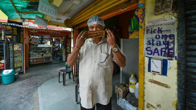 A man wears a mask stitched by Laxmi Das (unseen) near a free mask dispenser. The family’s initiative has also distributed masks among construction workers and people whose shanties were gutted in a major fire which broke out in Tughlakabad area earlier this month. (Arun Sharma / PTI) A man wears a mask stitched by Laxmi Das (unseen) near a free mask dispenser. The family’s initiative has also distributed masks among construction workers and people whose shanties were gutted in a major fire which broke out in Tughlakabad area earlier this month. (Arun Sharma / PTI)