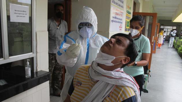 A doctor in PPE coveralls collects swab sample from people for coronavirus testing, during lockdown at Primary Health Centre (PHC) Wazirabad in Gurugram on Saturday.(Yogendra Kumar/HT Photo) A doctor in PPE coveralls collects swab sample from people for coronavirus testing, during lockdown at Primary Health Centre (PHC) Wazirabad in Gurugram on Saturday.(Yogendra Kumar/HT Photo)