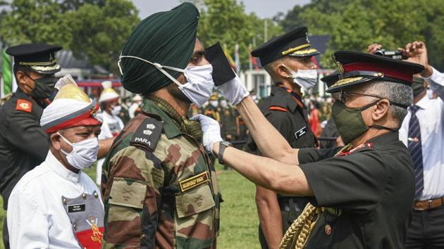 Army Chief General MM Naravane wearing a protective mask puts a star on the uniform of an army officer during a passing out parade amid the ongoing Covid-19 nationwide lockdown in Dehradun on Saturday.(PTI File Photo)