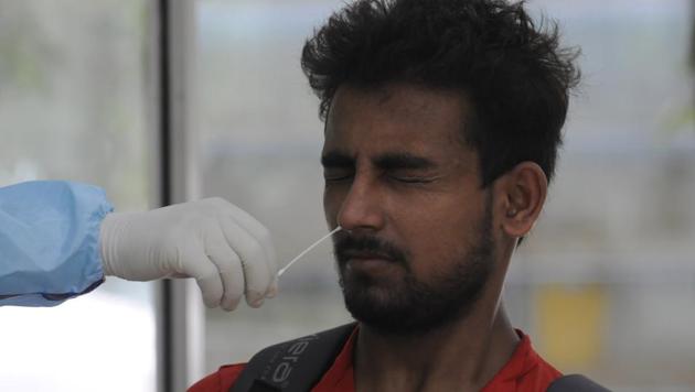 A medical professional collects swab sample from a man to conduct Covid-19 tests at District Hospital in Sector 30, Noida.(Sunil Ghosh / HT Photo)