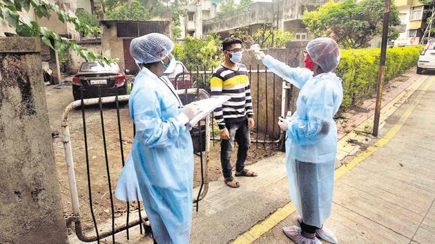 PMC workers screening a man during door-to-door survey at Dattawadi. (Pratham Gokhale/HT Photo) PMC workers screening a man during door-to-door survey at Dattawadi. (Pratham Gokhale/HT Photo)