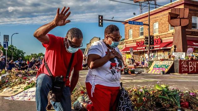 A couple kneels and raises their hands at a memorial for George Floyd following a day of demonstrations on June 13 in Minneapolis, Minnesota. Demonstrations against systemic racism being held across the US are now entering their fourth week following the death of Floyd, a black man who died on May 25 after a police officer knelt on his neck for nearly nine minutes. (Kerem Yucel / AFP) A couple kneels and raises their hands at a memorial for George Floyd following a day of demonstrations on June 13 in Minneapolis, Minnesota. Demonstrations against systemic racism being held across the US are now entering their fourth week following the death of Floyd, a black man who died on May 25 after a police officer knelt on his neck for nearly nine minutes. (Kerem Yucel / AFP)