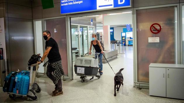 Passengers on a flight from Amsterdam wearing protective face masks arrive at the Eleftherios Venizelos International Airport in Athens on June 15. Greece's two main airports in Athens and Thessaloniki have reopened to arrivals from 29 countries, at the start of the tourist season. (Angelos Tzortzinis / AFP)