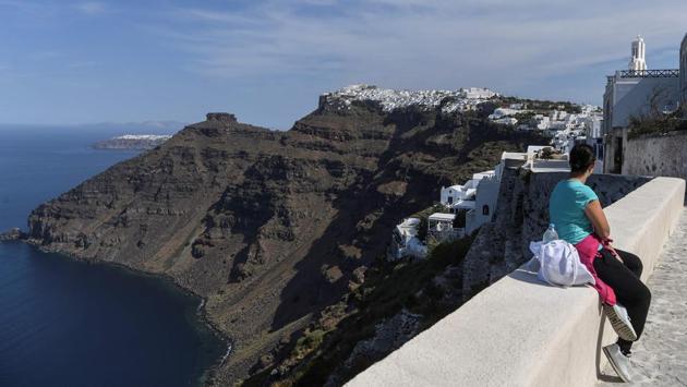 A woman gazes across the view of the town of Fyra on the island of Santorini on June 14. Greece is officially open to tourists as of today, with the first international flights landing into Athens and the northern city of Thessaloniki where passengers have to face compulsory coronavirus tests. (Aris Messinis / AFP)