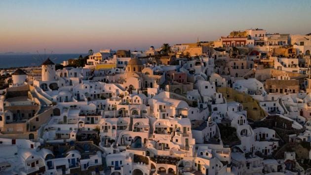 A view of the sunset in the town of Oia on the island of Santorini as the country prepares for the return of tourists to Greece. From its postcard landscape splashed with sunshine, the island of Santorini, one of the most scenic places in Greece, awaits the return of tourists . (Aris Messinis / AFP)