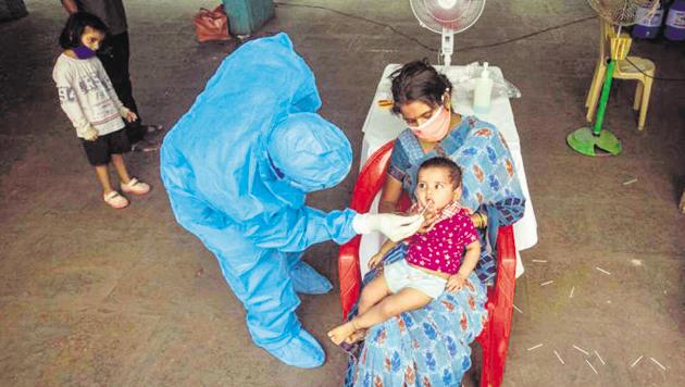 A healthcare worker collects an oral swab sample of a child for Covid-19 test, at Sane Guruji Smarak.(Pratham Gokhale/HT Photo)
