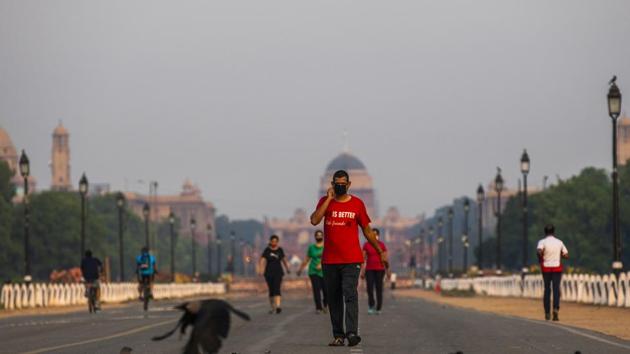 People walk along Rajpath boulevard as the Rashtrapati Bhavan stands in the background during a partial lockdown imposed due to the coronavirus in New Delhi. (Bloomberg) People walk along Rajpath boulevard as the Rashtrapati Bhavan stands in the background during a partial lockdown imposed due to the coronavirus in New Delhi. (Bloomberg)