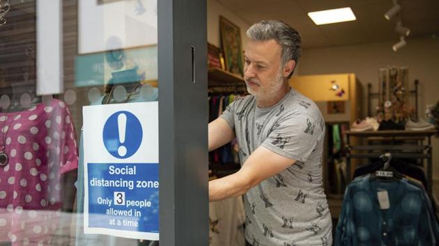 A shop owner installs a sign in the window of his store, ahead of its reopening in Stratford-upon-Avon, Warwickshire, England on Sunday. (AP Photo) A shop owner installs a sign in the window of his store, ahead of its reopening in Stratford-upon-Avon, Warwickshire, England on Sunday. (AP Photo)