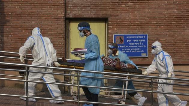 Medical professionals wearing PPE coveralls escort a patient suspected of coronavirus infection into the the Covid-19 ward at LNJP Hospital in New Delhi.(Vipin Kumar/HT PHOTO) Medical professionals wearing PPE coveralls escort a patient suspected of coronavirus infection into the the Covid-19 ward at LNJP Hospital in New Delhi.(Vipin Kumar/HT PHOTO)