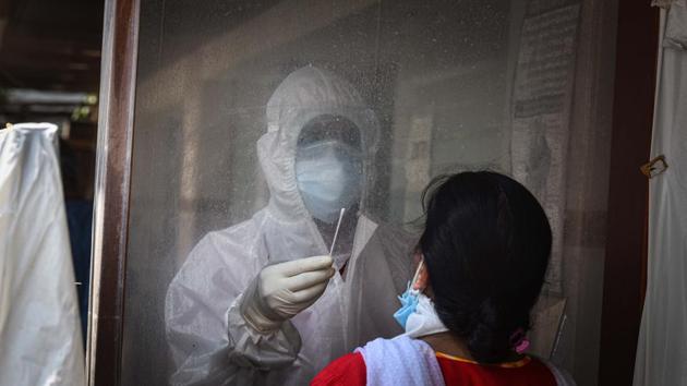 A medical worker wearing PPE coveralls collects a swab sample from a woman to test for Covid-19 infection.(Sanchit Khanna/HT PHOTO) A medical worker wearing PPE coveralls collects a swab sample from a woman to test for Covid-19 infection.(Sanchit Khanna/HT PHOTO)